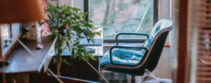 A working from home set-up including a desk, chair and plant