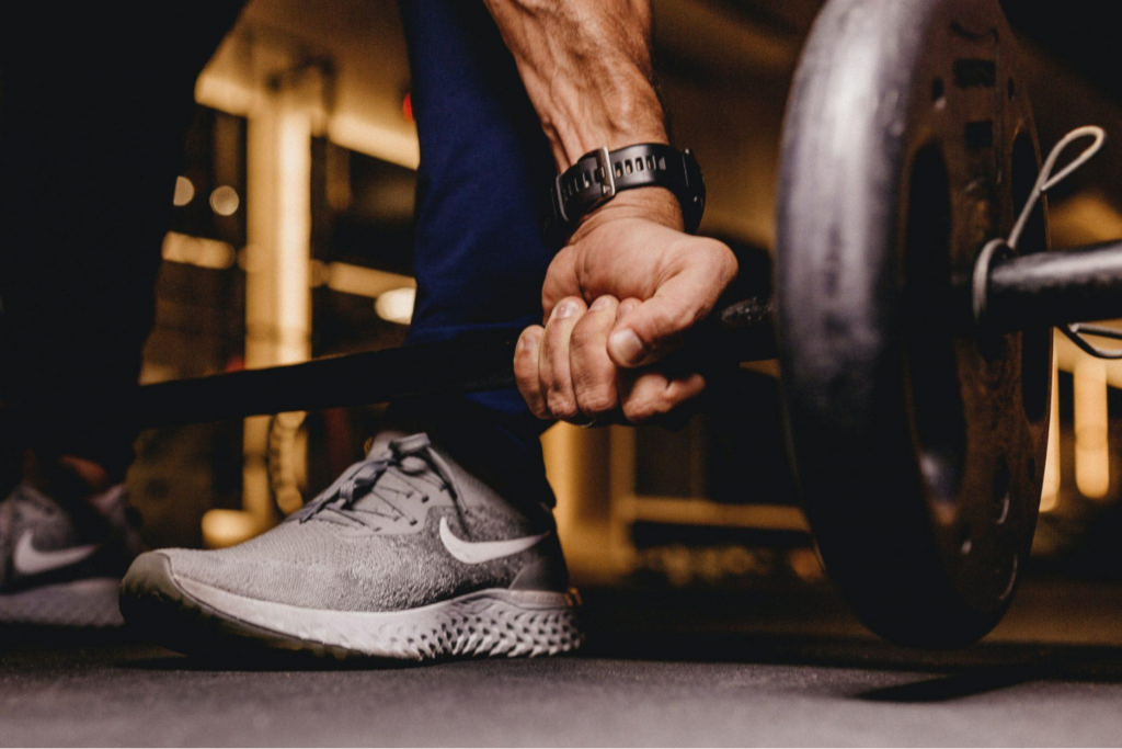 A person lifting a barbell from the floor