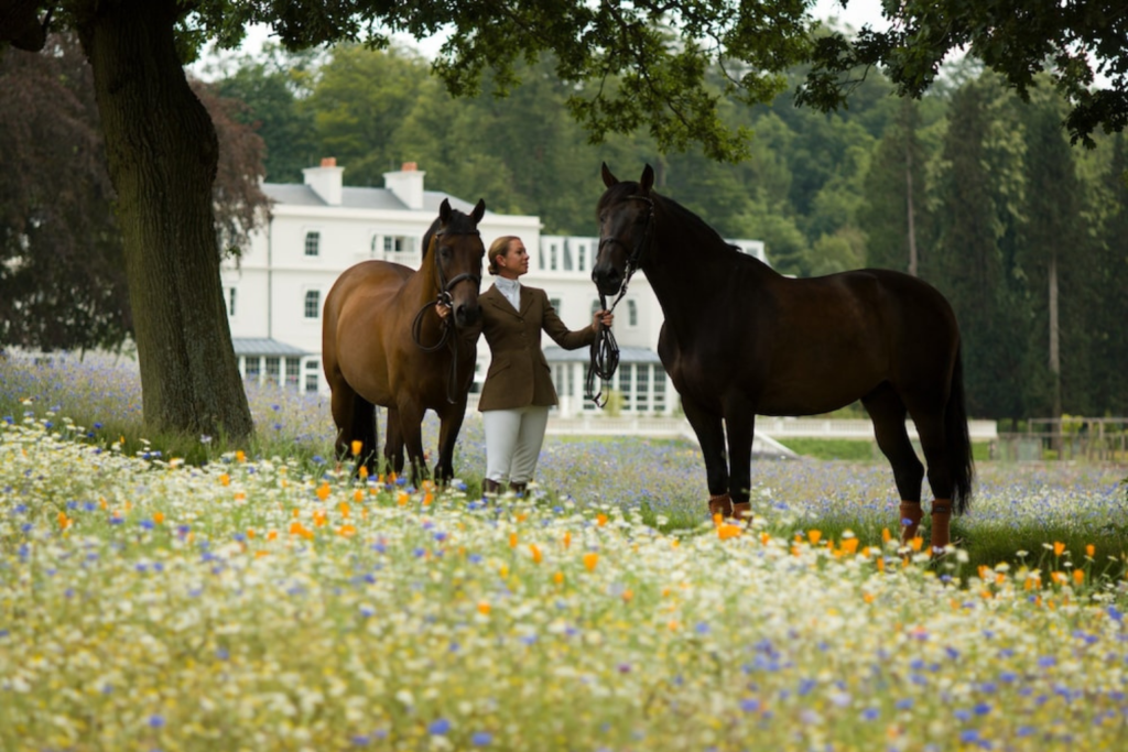 Ten Private Membership - Ten Members' Choice: Best Boutique Hotels In The UK WOman with 2 horses outside of Coworth Park