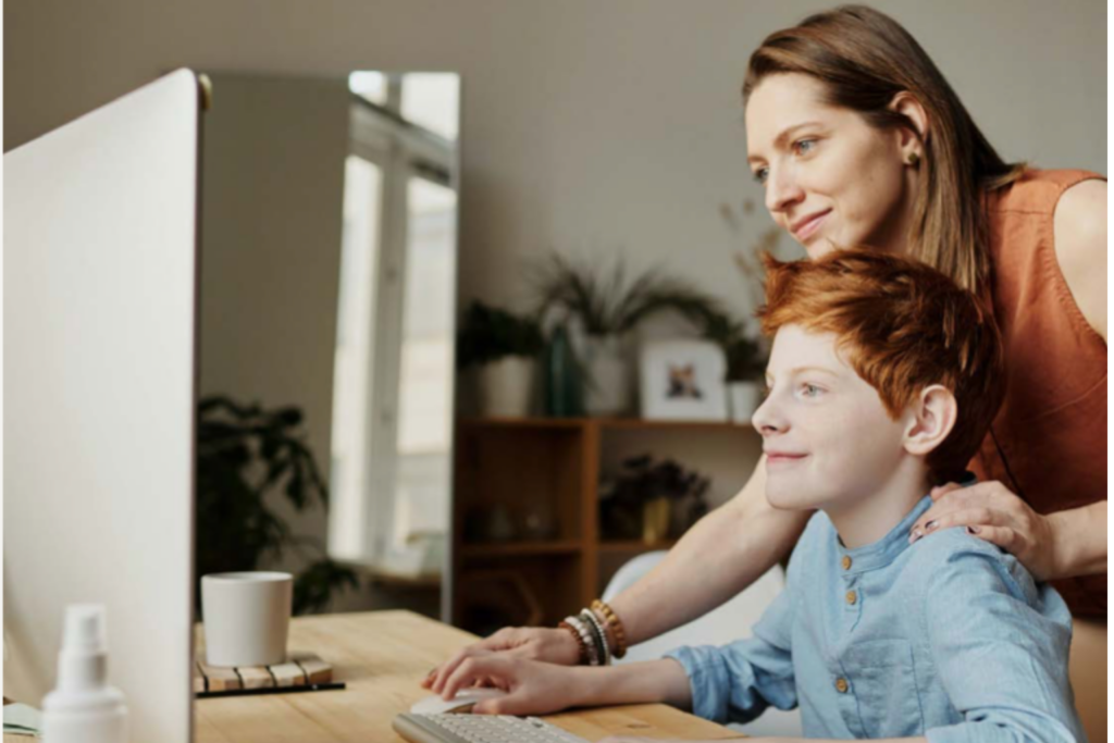 A mother and son on a computer together